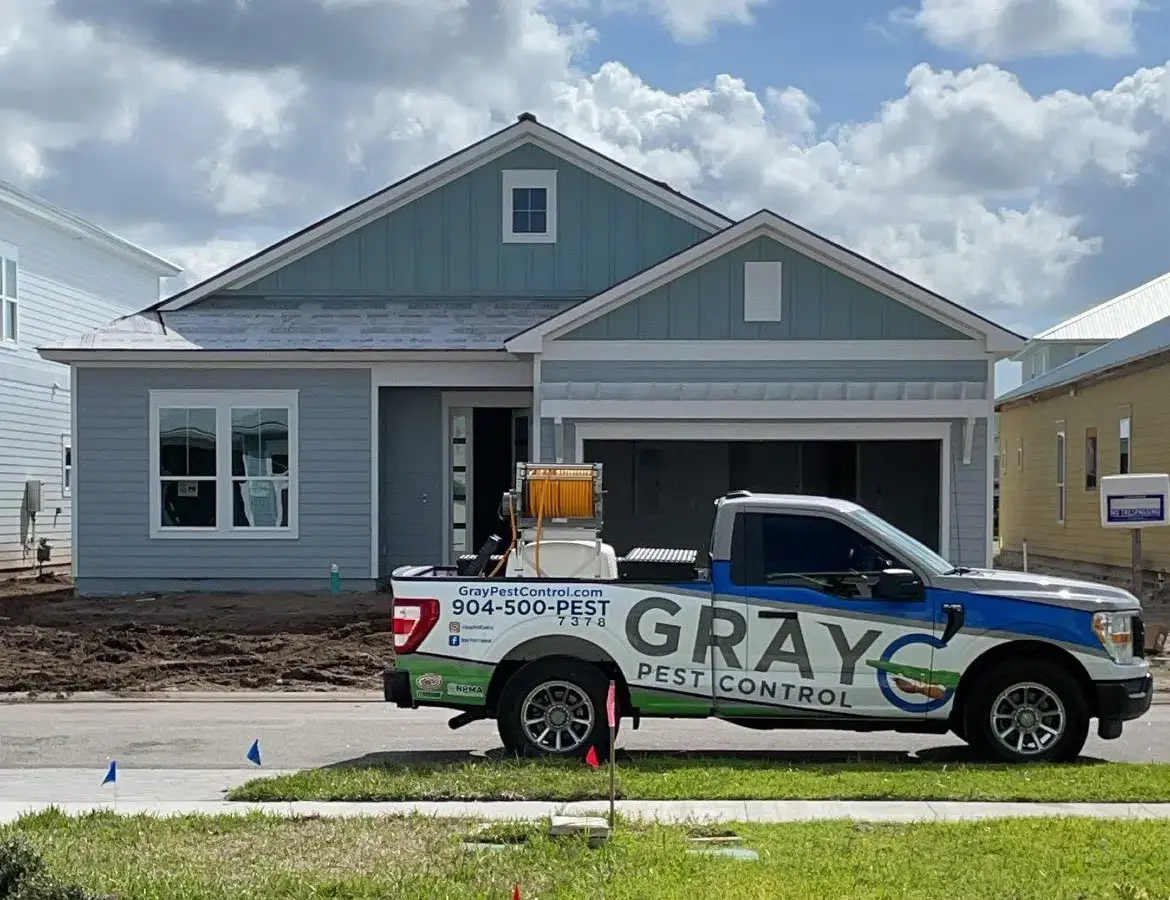 Gray Pest Control service truck parked in front of a Northeast Florida home